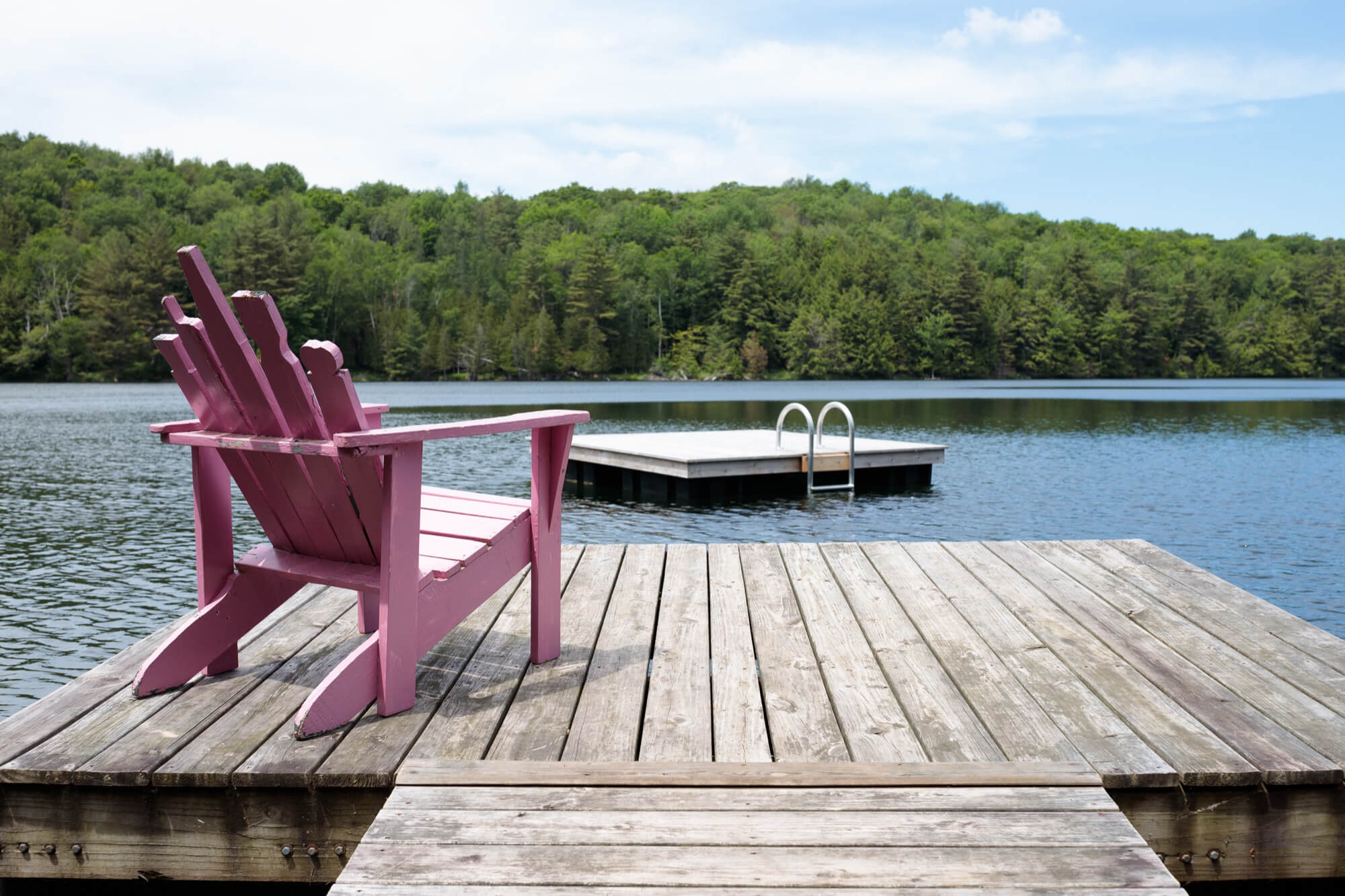pink chair on dock on lake