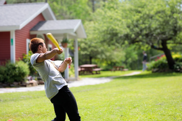 young man swinging wiffle ball bat